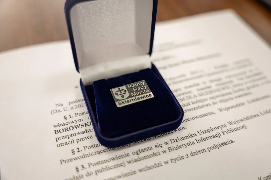 Srebrna odznaka radnego Rady Miasta Skierniewice w niebieskim etui na tle dokumentu powołania. fot. Adam Sobieszek