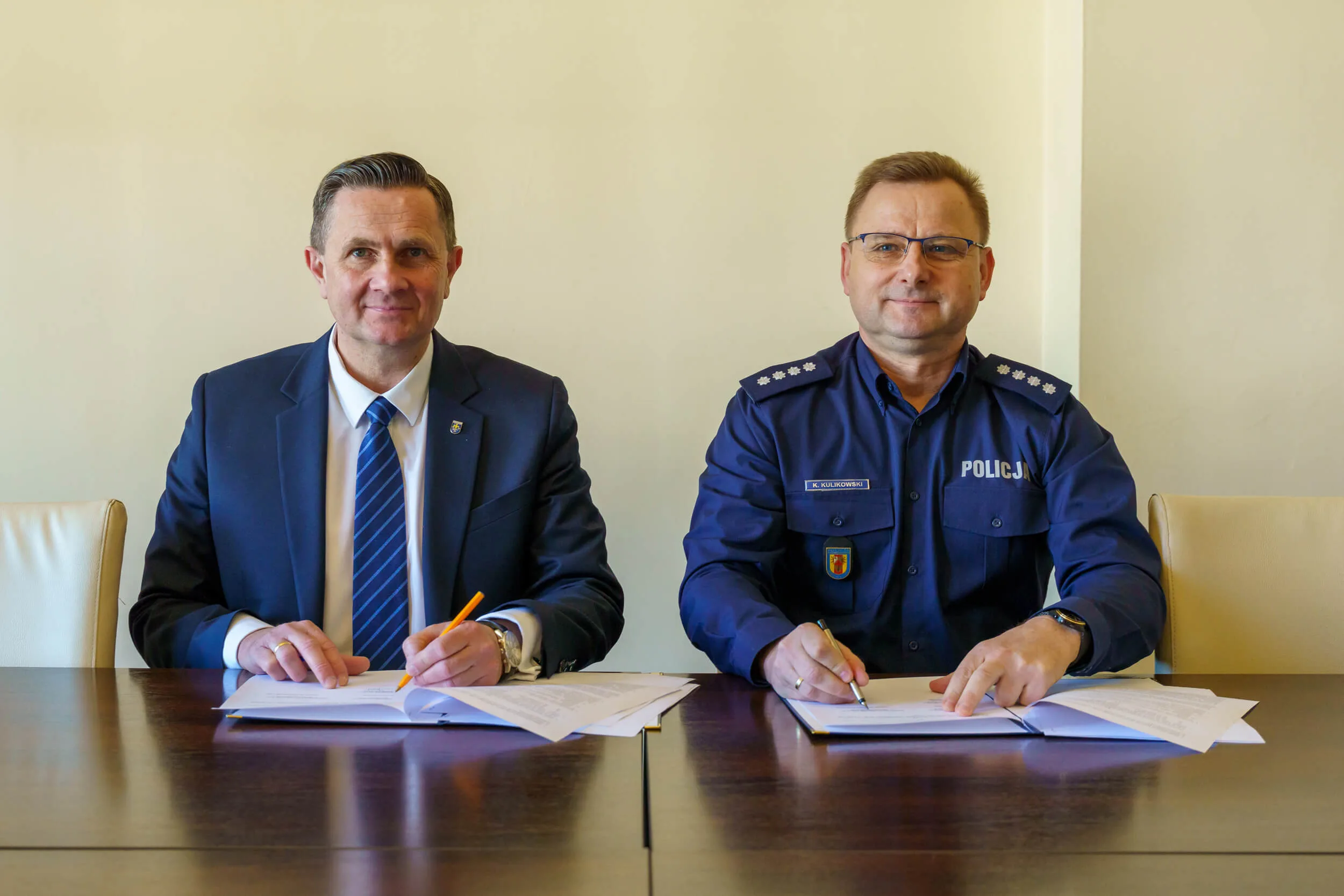 Prezydent Krzysztof Jażdżyk i nadkom. Krzysztof Kulikowski podpisują porozumienie o współpracy w ratuszu.