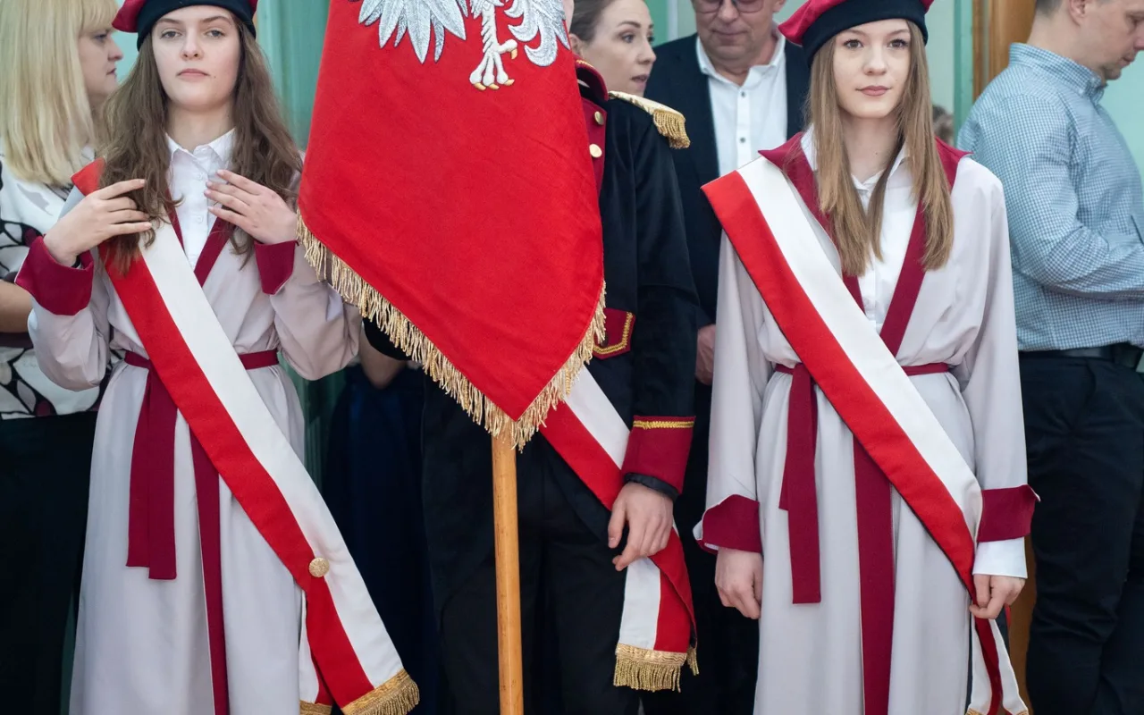 Występ artystyczny uczniów podczas oficjalnej akademii z okazji 110-lecia SP 2 w Skierniewicach, na scenie baner jubileuszowy.