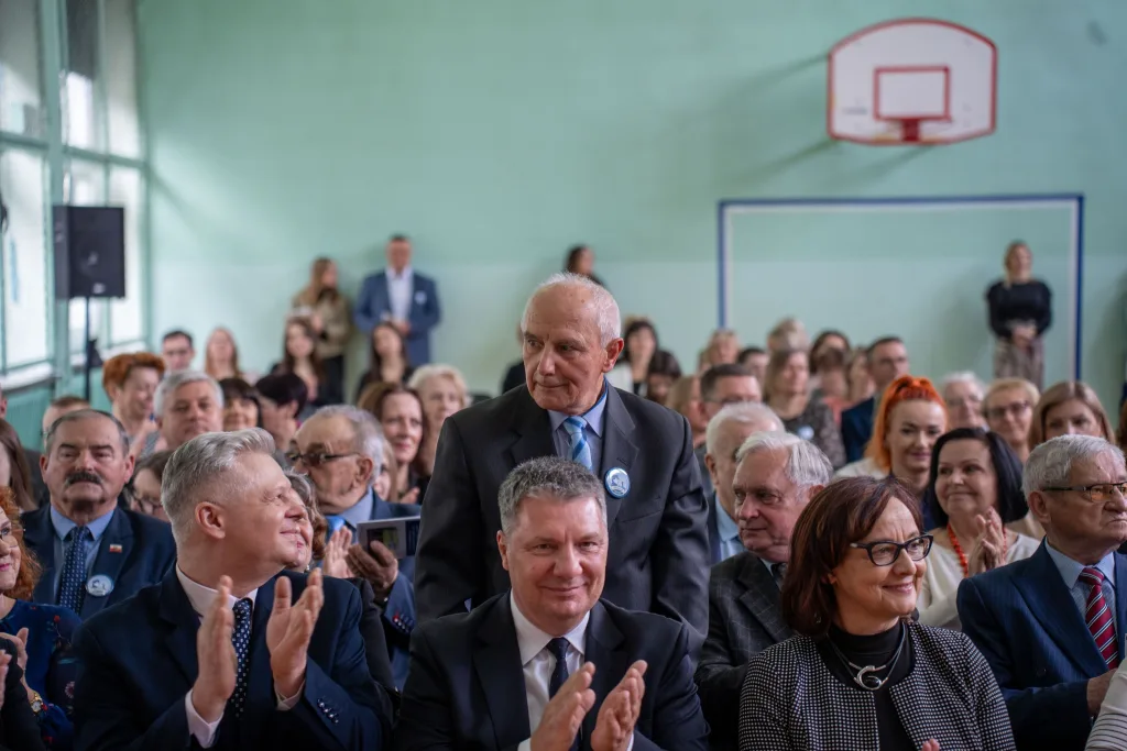 Występ artystyczny uczniów podczas oficjalnej akademii z okazji 110-lecia SP 2 w Skierniewicach, na scenie baner jubileuszowy.