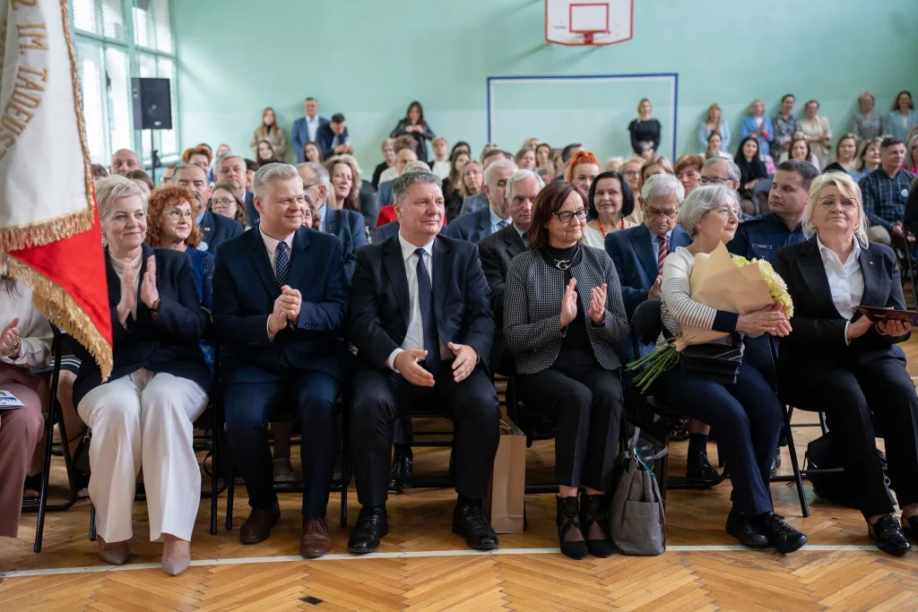 Występ artystyczny uczniów podczas oficjalnej akademii z okazji 110-lecia SP 2 w Skierniewicach, na scenie baner jubileuszowy.