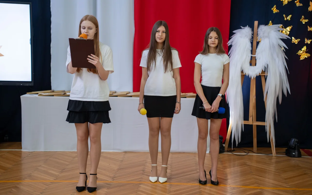 Występ artystyczny uczniów podczas oficjalnej akademii z okazji 110-lecia SP 2 w Skierniewicach, na scenie baner jubileuszowy.