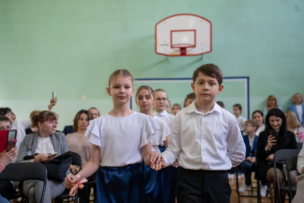 Występ artystyczny uczniów podczas oficjalnej akademii z okazji 110-lecia SP 2 w Skierniewicach, na scenie baner jubileuszowy.