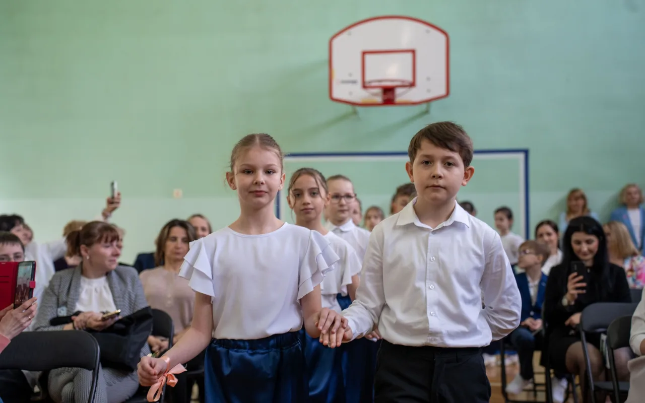 Występ artystyczny uczniów podczas oficjalnej akademii z okazji 110-lecia SP 2 w Skierniewicach, na scenie baner jubileuszowy.