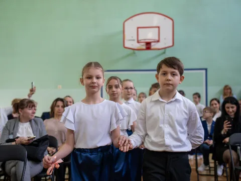 Występ artystyczny uczniów podczas oficjalnej akademii z okazji 110-lecia SP 2 w Skierniewicach, na scenie baner jubileuszowy.