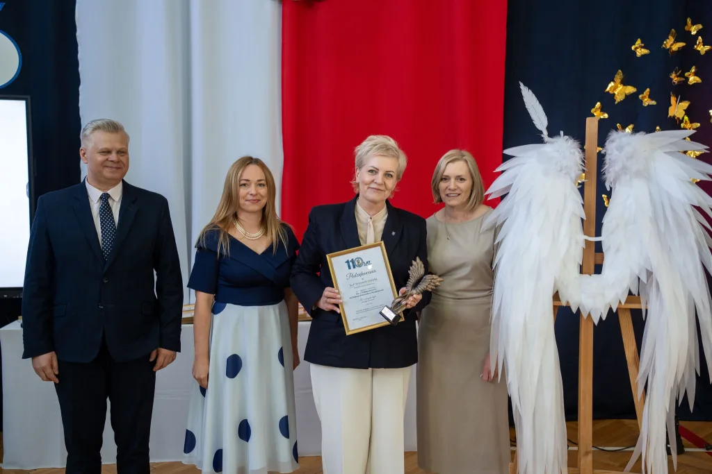 Występ artystyczny uczniów podczas oficjalnej akademii z okazji 110-lecia SP 2 w Skierniewicach, na scenie baner jubileuszowy.
