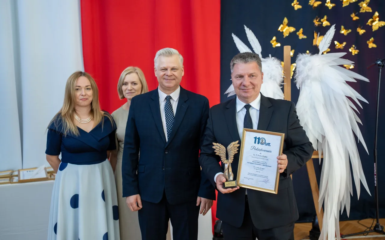 Występ artystyczny uczniów podczas oficjalnej akademii z okazji 110-lecia SP 2 w Skierniewicach, na scenie baner jubileuszowy.