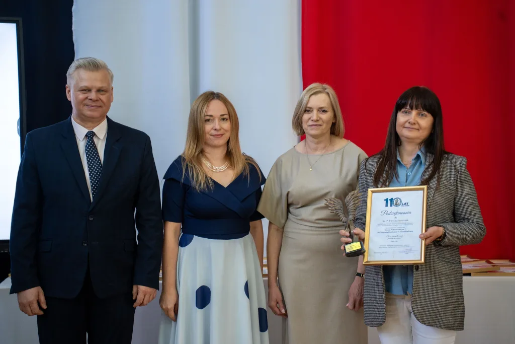 Występ artystyczny uczniów podczas oficjalnej akademii z okazji 110-lecia SP 2 w Skierniewicach, na scenie baner jubileuszowy.