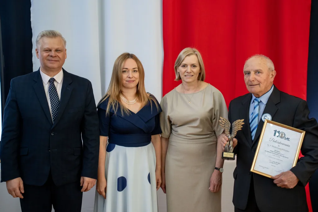 Występ artystyczny uczniów podczas oficjalnej akademii z okazji 110-lecia SP 2 w Skierniewicach, na scenie baner jubileuszowy.