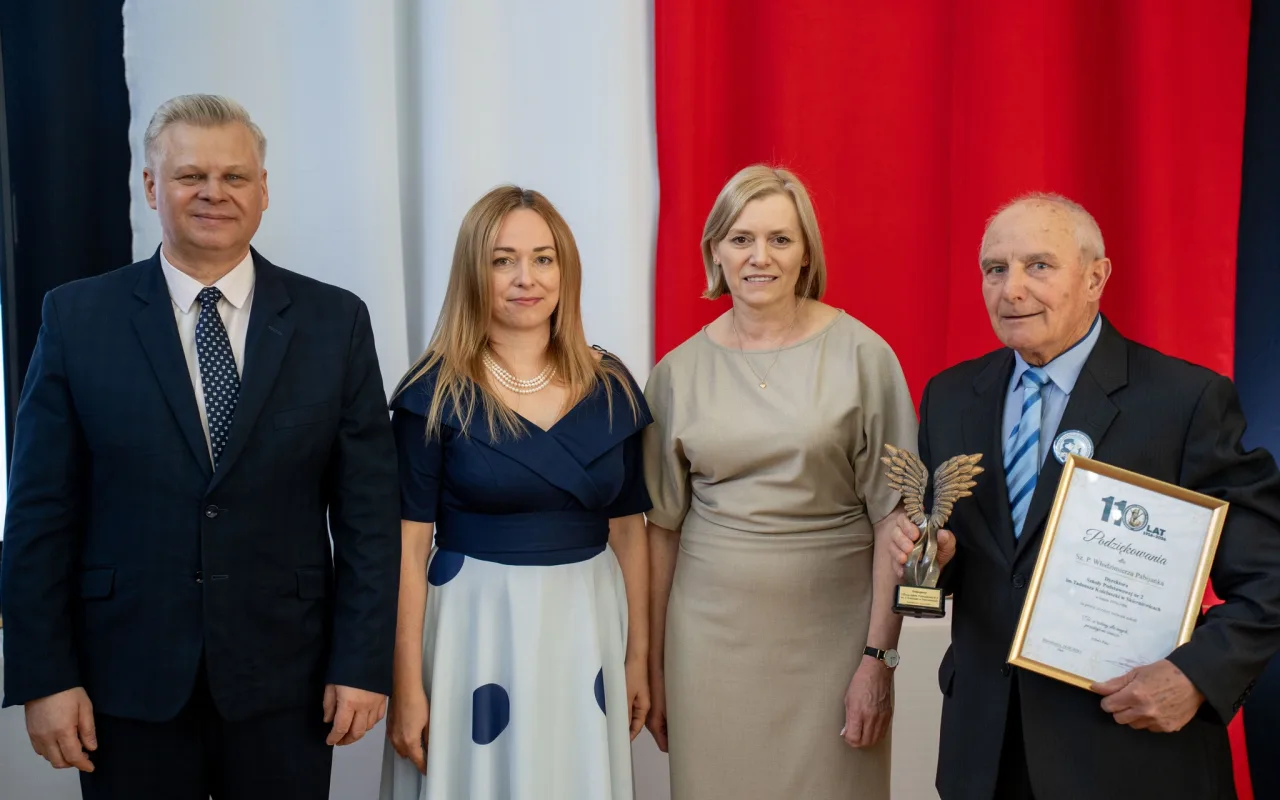 Występ artystyczny uczniów podczas oficjalnej akademii z okazji 110-lecia SP 2 w Skierniewicach, na scenie baner jubileuszowy.