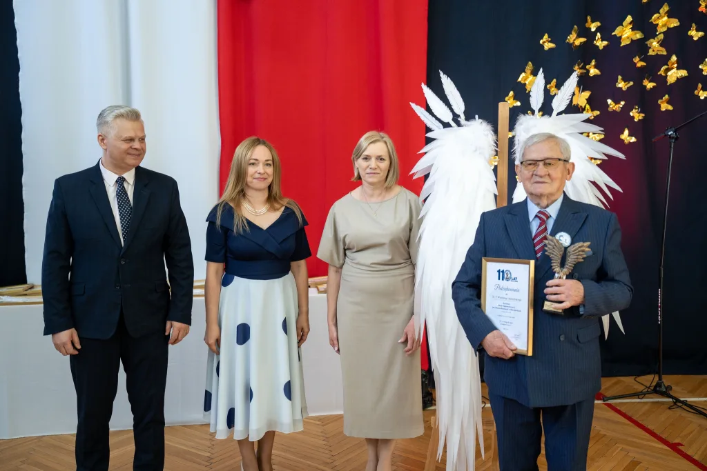 Występ artystyczny uczniów podczas oficjalnej akademii z okazji 110-lecia SP 2 w Skierniewicach, na scenie baner jubileuszowy.