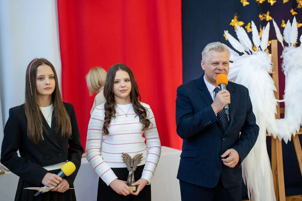 Występ artystyczny uczniów podczas oficjalnej akademii z okazji 110-lecia SP 2 w Skierniewicach, na scenie baner jubileuszowy.