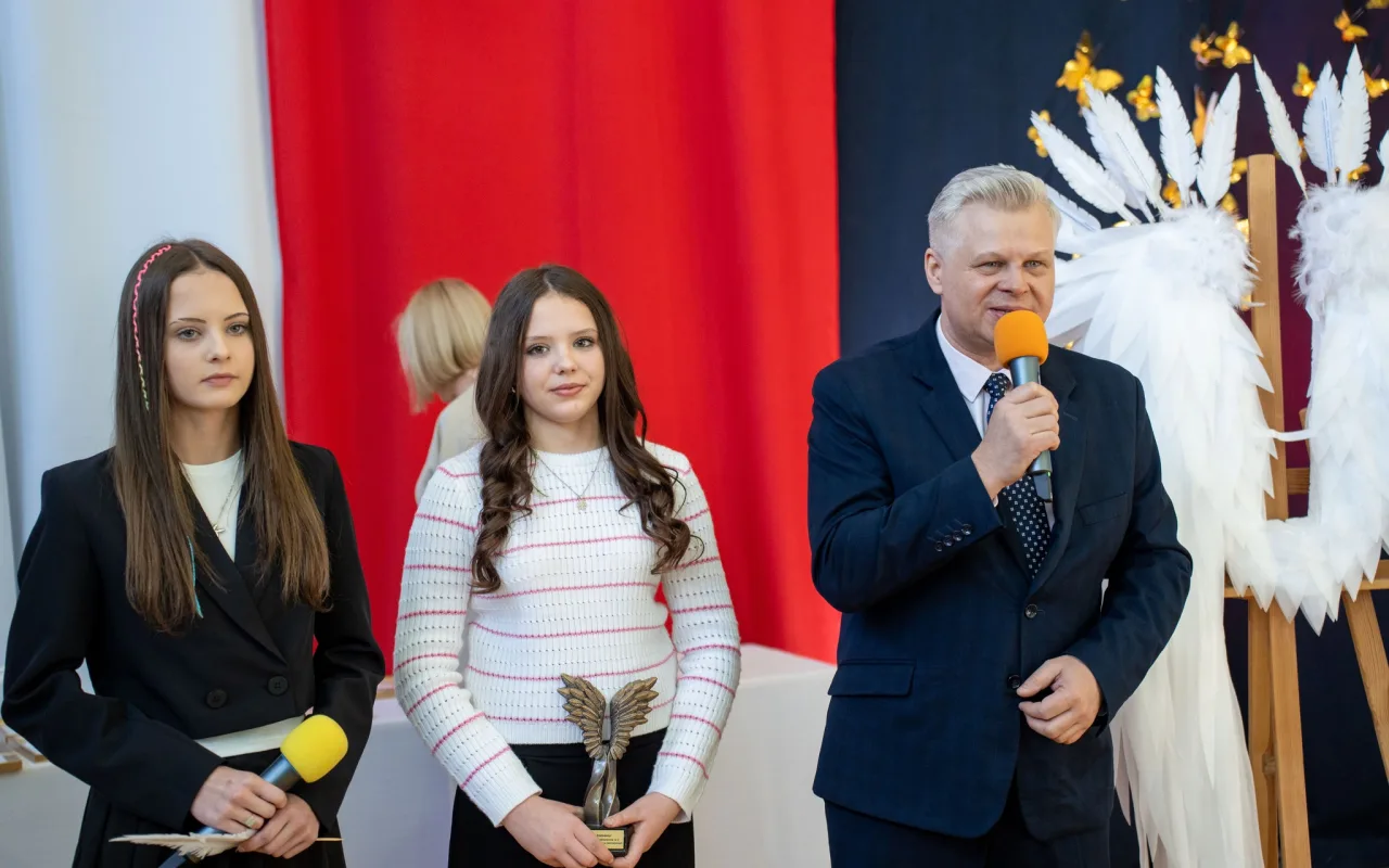 Występ artystyczny uczniów podczas oficjalnej akademii z okazji 110-lecia SP 2 w Skierniewicach, na scenie baner jubileuszowy.