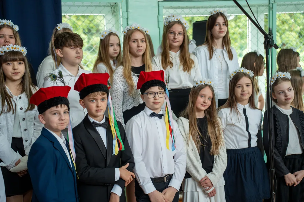 Występ artystyczny uczniów podczas oficjalnej akademii z okazji 110-lecia SP 2 w Skierniewicach, na scenie baner jubileuszowy.