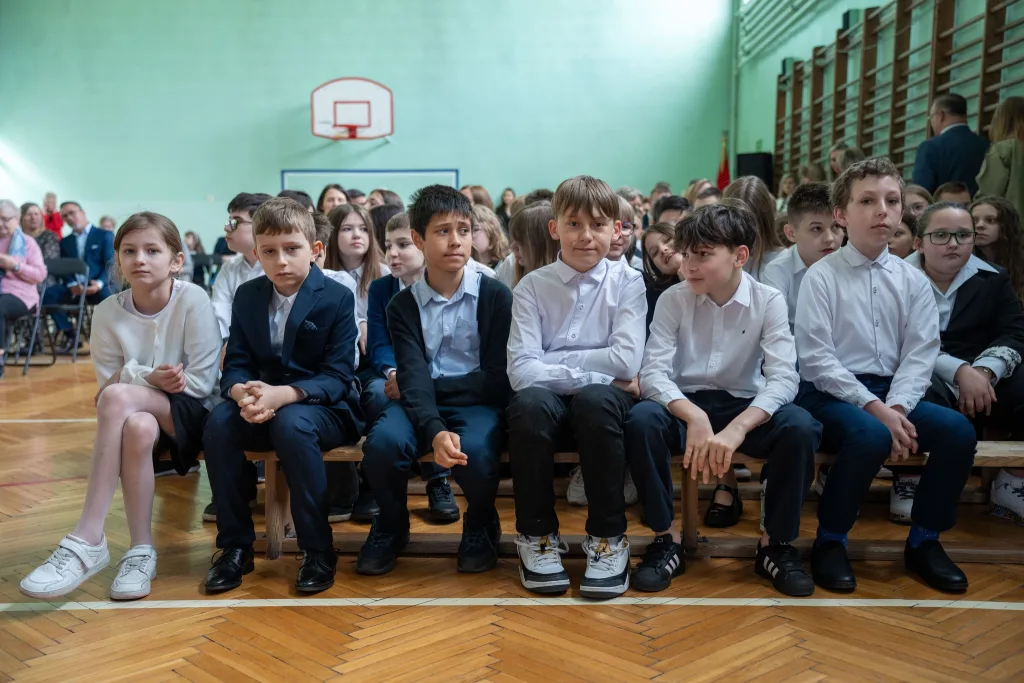 Występ artystyczny uczniów podczas oficjalnej akademii z okazji 110-lecia SP 2 w Skierniewicach, na scenie baner jubileuszowy.