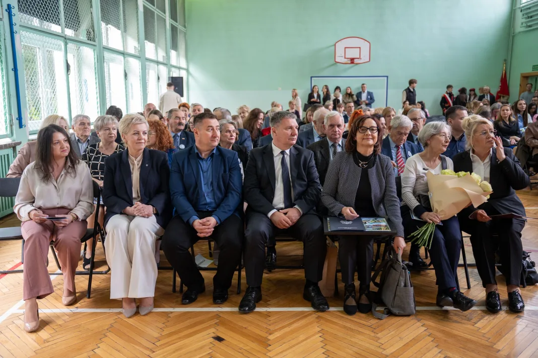 Występ artystyczny uczniów podczas oficjalnej akademii z okazji 110-lecia SP 2 w Skierniewicach, na scenie baner jubileuszowy.