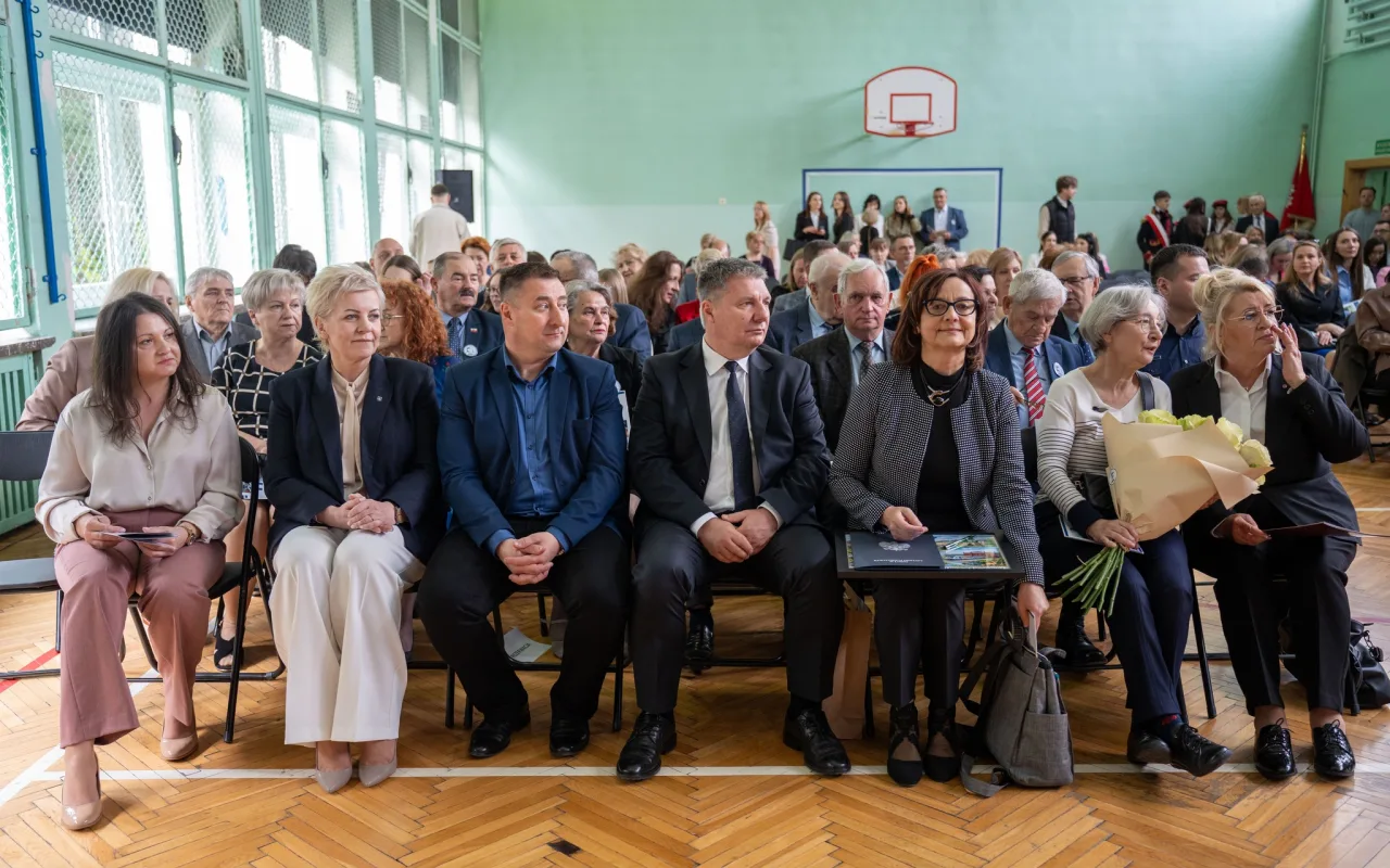 Występ artystyczny uczniów podczas oficjalnej akademii z okazji 110-lecia SP 2 w Skierniewicach, na scenie baner jubileuszowy.