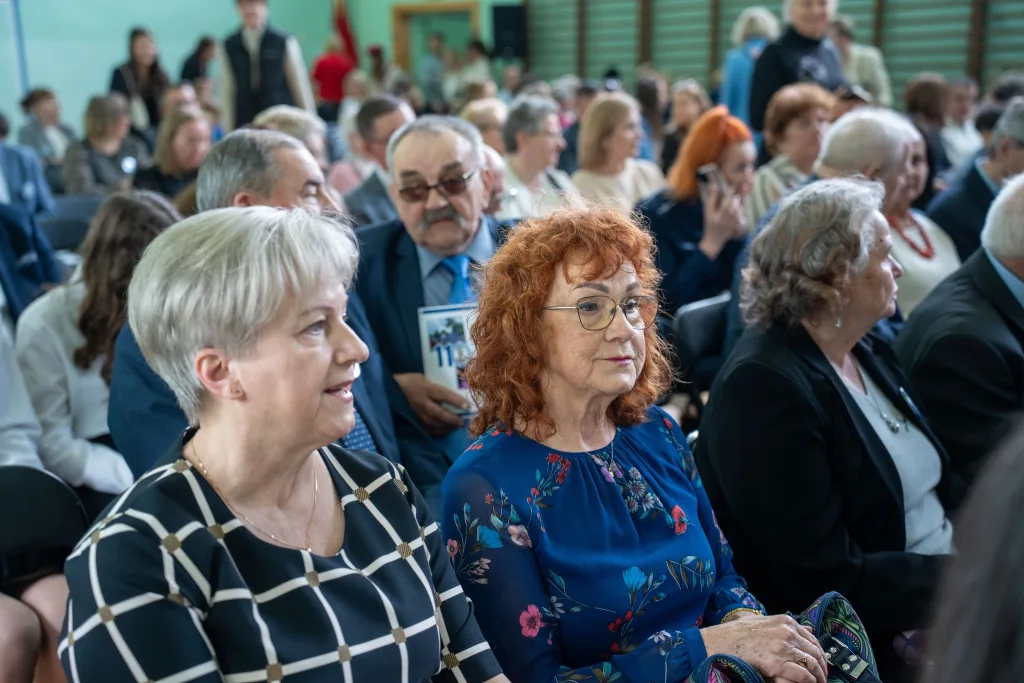 Występ artystyczny uczniów podczas oficjalnej akademii z okazji 110-lecia SP 2 w Skierniewicach, na scenie baner jubileuszowy.
