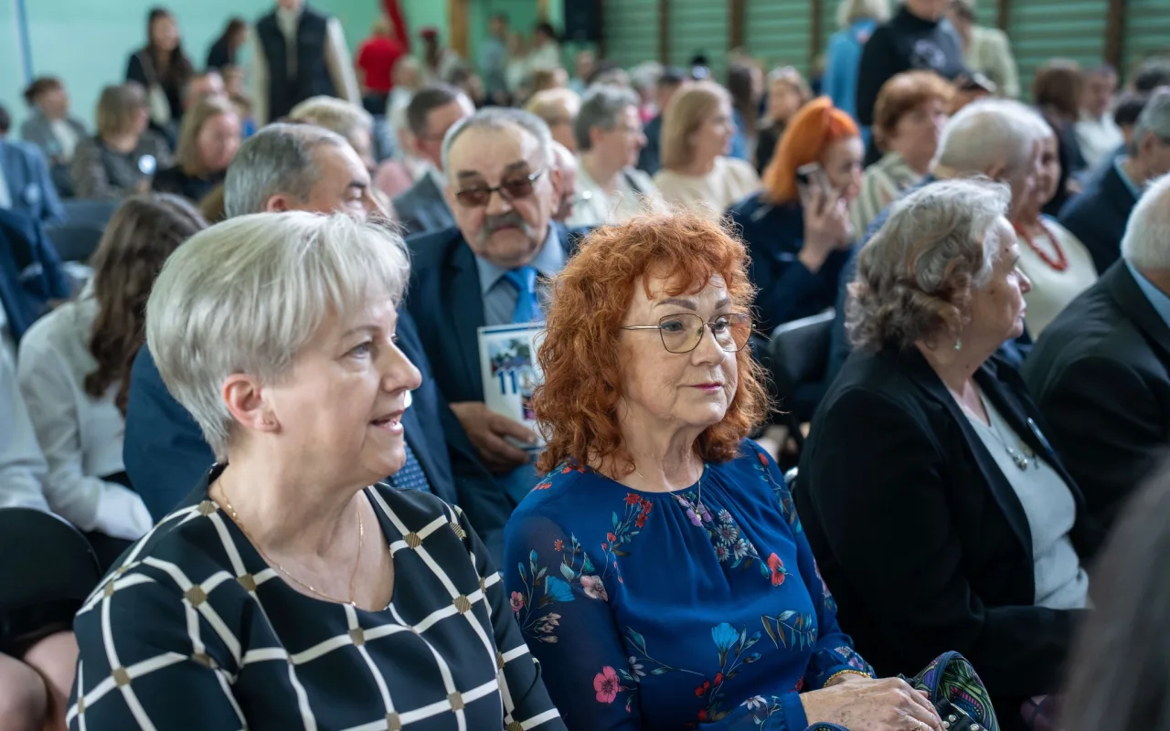 Występ artystyczny uczniów podczas oficjalnej akademii z okazji 110-lecia SP 2 w Skierniewicach, na scenie baner jubileuszowy.