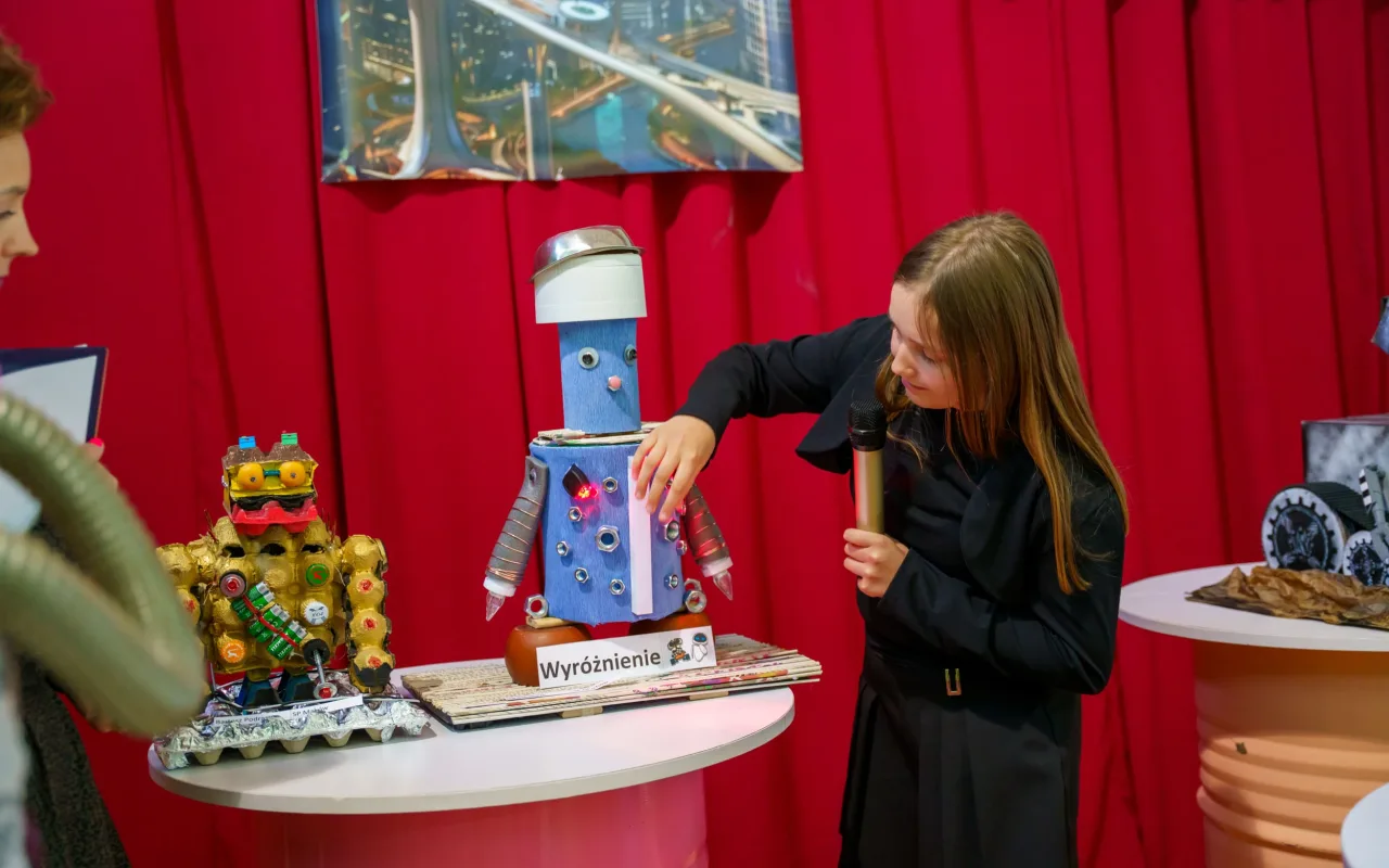 Uczeń prezentuje robota z materiałów recyklingowych podczas V Powiatowego Konkursu Technicznego w Skierniewicach