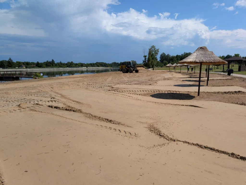 Plaża nad Zalewem Żyrardowskim z parasolami i brzegiem kąpieliska Gdzie nad wodę Skierniewice